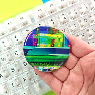 Colorful pixelated button held over a keyboard