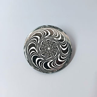 Button with black and white spiral pattern on a light gray background