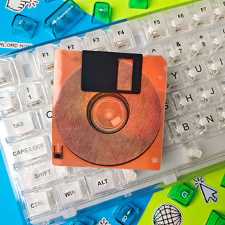 Neon Orange Floppy disk on a transparent keyboard with colorful keycaps