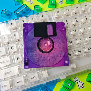 Purple floppy disk on a transparent keyboard with colorful keycaps