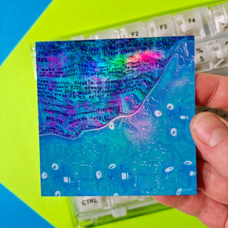 Hand holding a colorful abstract art piece with text overlay on a keyboard background