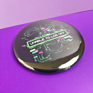 Round metallic object with electronic circuit design and 'UNABLE TO LOG OFF' text on a purple background