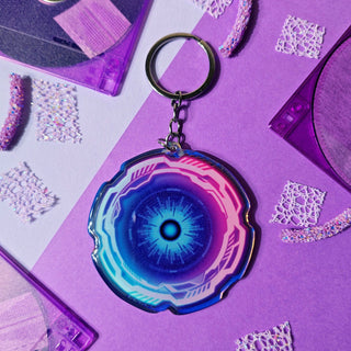 Keychain with a blue and pink design on a purple surface with decorative elements