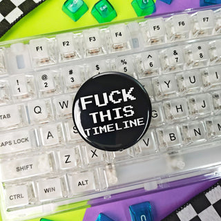 Clear keyboard with a button labeled 'Fuck This Timeline' on a colorful background