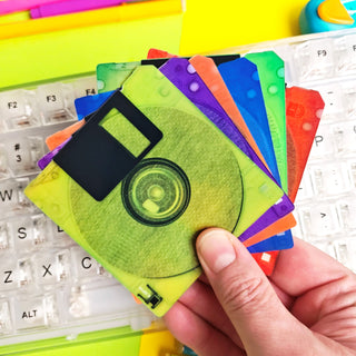 Colorful floppy discs held over a keyboard