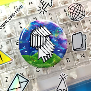 Keyboard with a colorful button featuring a white cursor icon on a grassy landscape.
