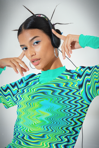 Person wearing a vibrant, patterned shirt with a plain background