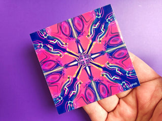 Colorful abstract design on a square card held against a purple background