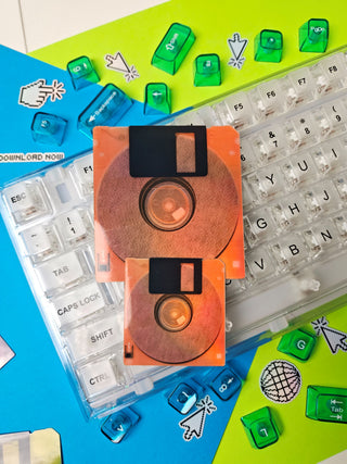Neon Orange Floppy disks on a colorful keyboard with keycaps and stickers.
