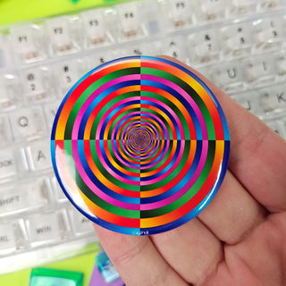 Colorful spiral design held by a hand on a keyboard background