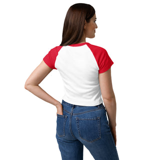 Woman wearing a red and white baseball-style shirt with blue jeans on a white background.
