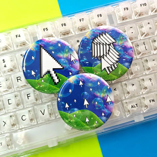 Three colorful buttons with computer-themed designs on a keyboard