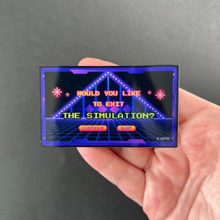 Retro Game Exit The Simulation Holographic Sticker by AIPYR laying on a human hand over a black background.