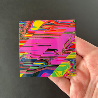 Slant Glitch Holographic Sticker by AIPYR laying on a human hand over a black background.