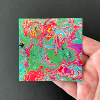 Slime Teal Swirl Holographic Sticker by AIPYR laying on a human hand over a black background.