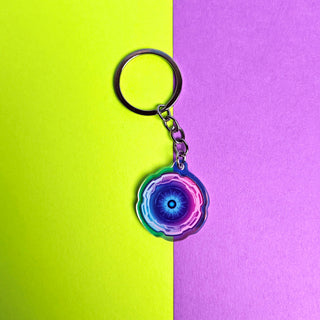 Keychain with a colorful design on a two-tone yellow and purple background
