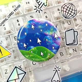 Round button with a colorful design of a landscape with bubbles and arrows on a keyboard background