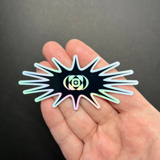 Y2K Totality Star Holographic Sticker by AIPYR laying on a human hand over a black background.