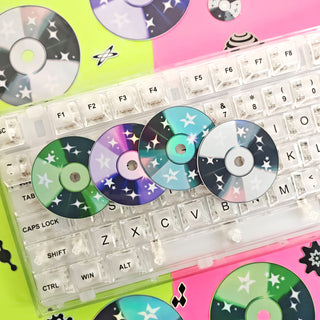 Colorful CDs with star patterns on a transparent keyboard