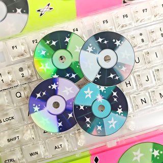 Colorful CDs with star patterns on a transparent keyboard