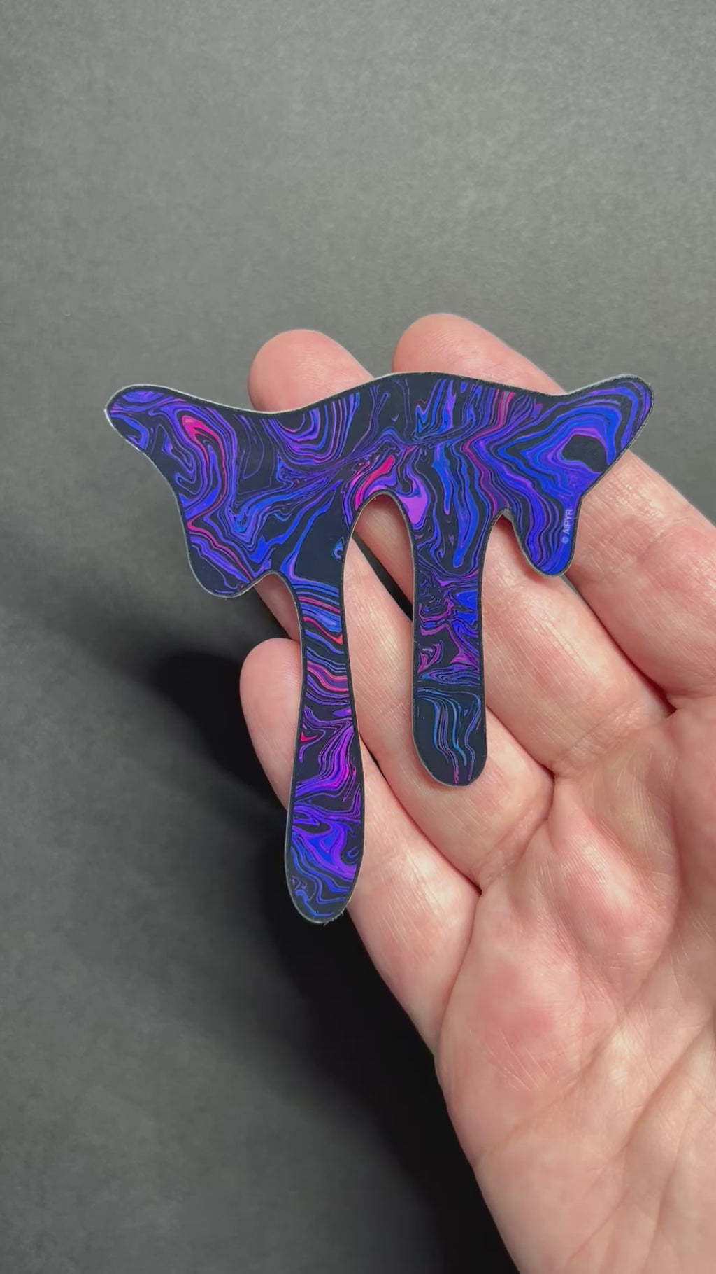 Video of the Dark Purple Drip Holographic Sticker by AIPYR over a black background.